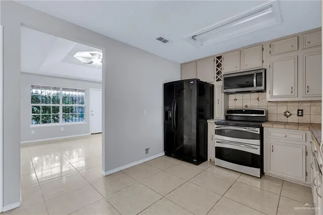 a kitchen with stainless steel appliances a refrigerator and a stove top oven