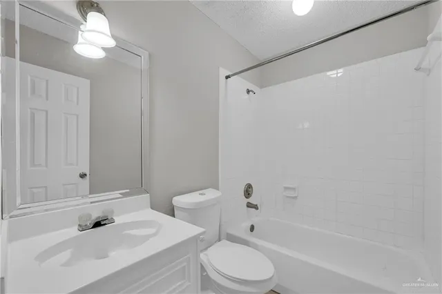 a bathroom with a bathtub shower sink vanity mirror and toilet