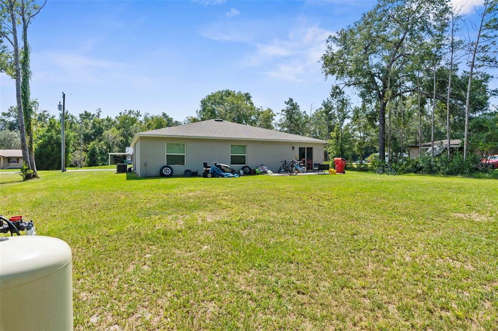 5637 East Tangelo Lane Inverness, FL 34453 - Photo 21 of 23 a white house with a big yard and large trees