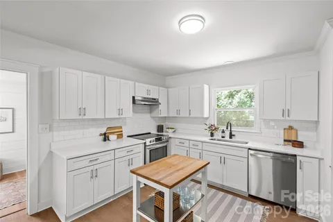 a kitchen with cabinets appliances a sink and a window