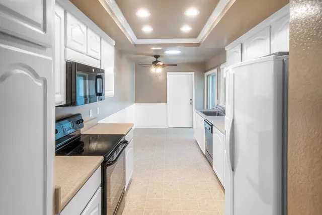 a kitchen with granite countertop a sink stove and cabinets