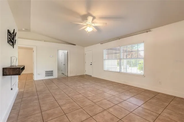 an empty room with windows and fan