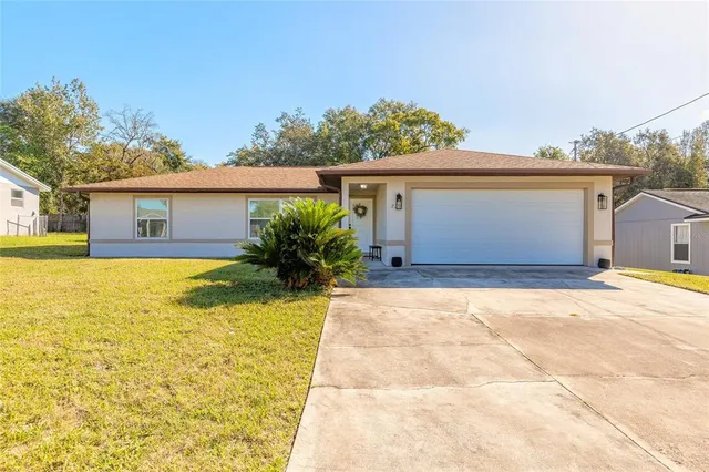 a front view of house with yard and trees around