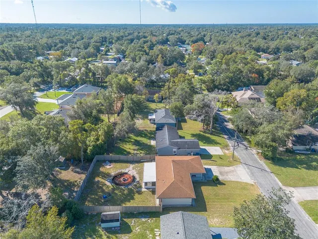 an aerial view of residential houses with outdoor space and trees