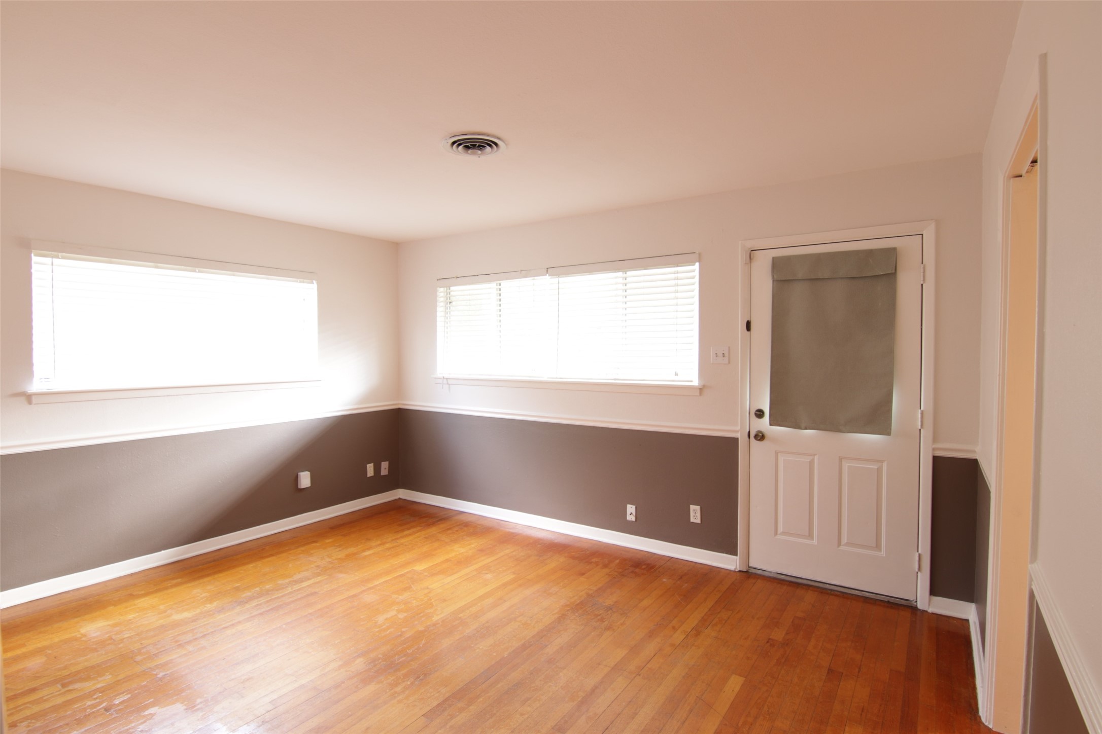 7030 Sharpview Drive Houston, TX 77074 - Photo 3 of 20 an empty room with wooden floor and windows