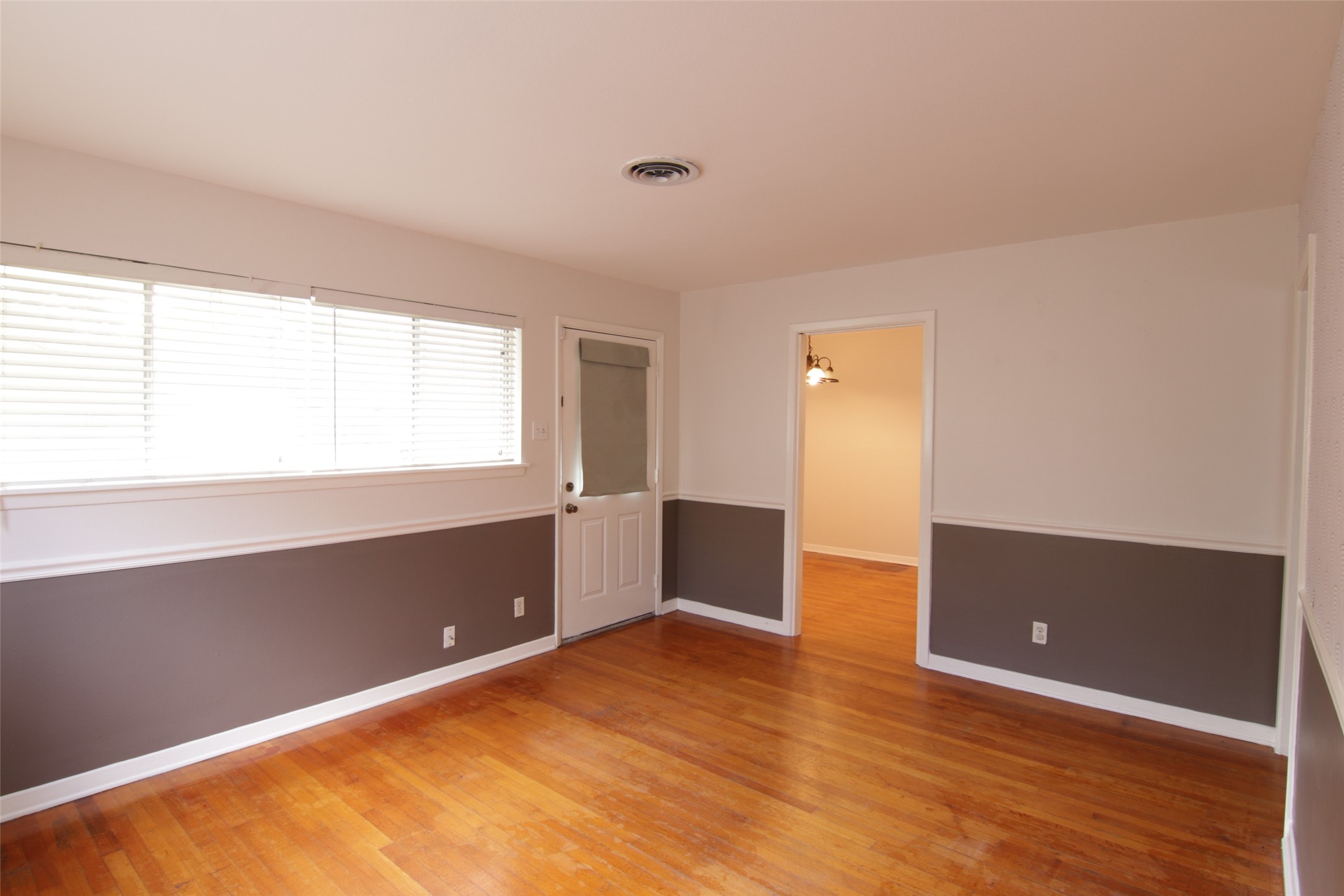 7030 Sharpview Drive Houston, TX 77074 - Photo 4 of 20 a view of an empty room with wooden floor and a window