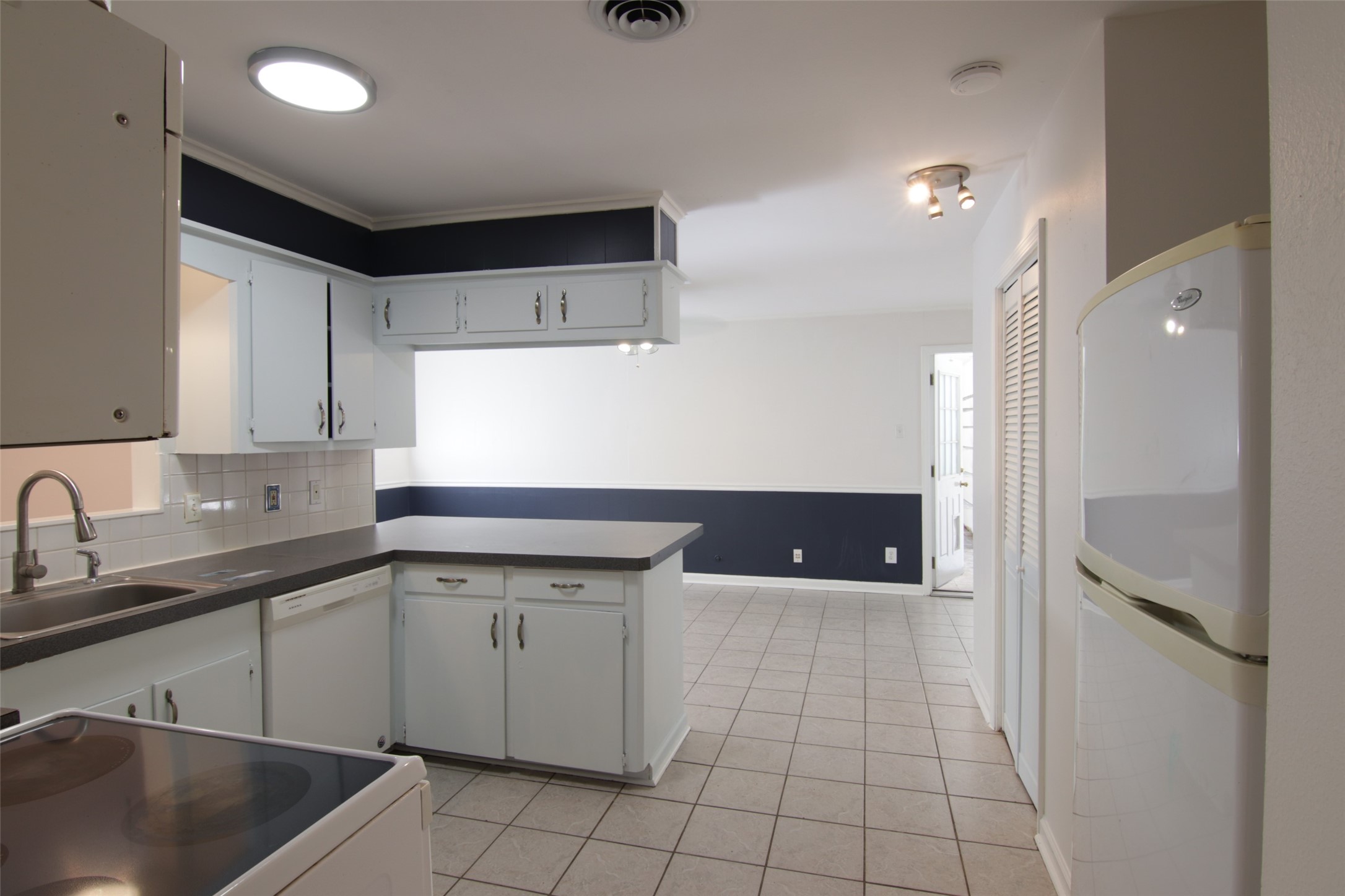 7030 Sharpview Drive Houston, TX 77074 - Photo 7 of 20 a kitchen with a sink a refrigerator and cabinets