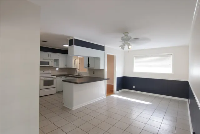 a large white kitchen with a sink