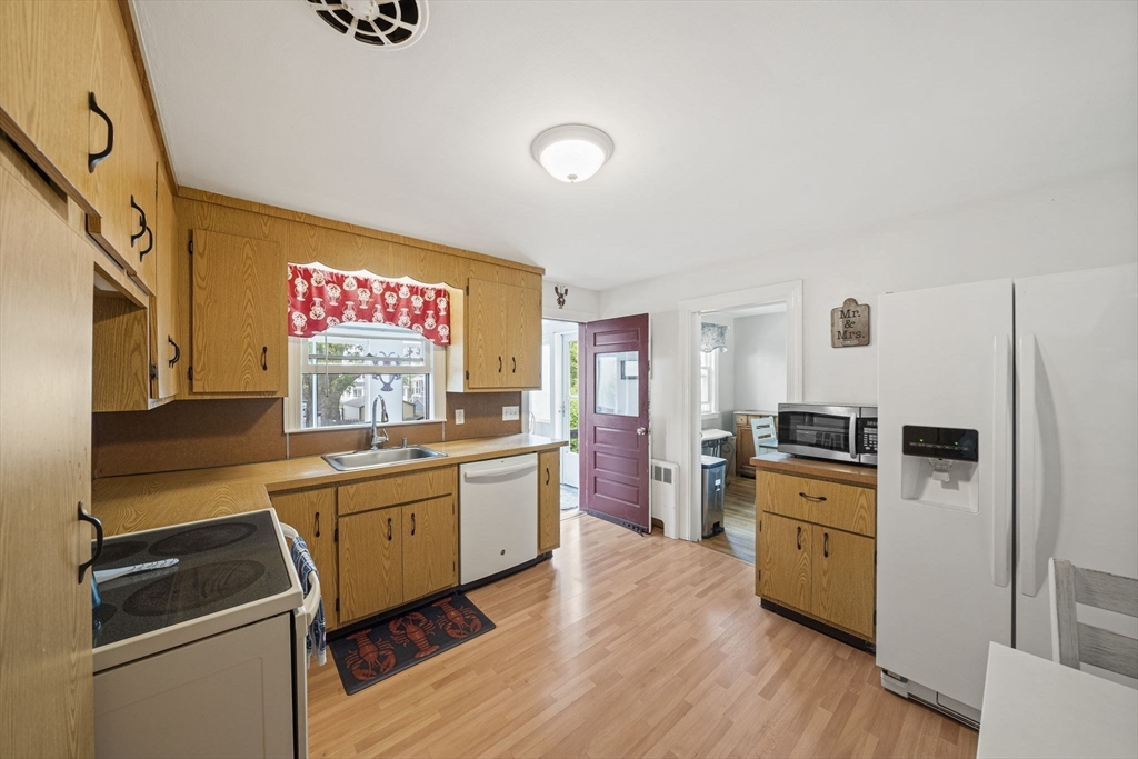 15 D Street Hull, MA 02045 - Photo 3 of 42 a kitchen with granite countertop a sink appliances wooden floor and cabinets