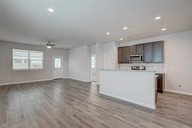 a view of kitchen with granite countertop cabinets and wooden floor