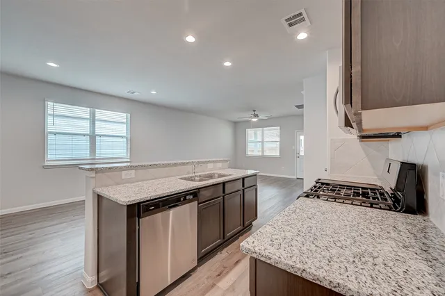 a kitchen with a stove and a wooden floor