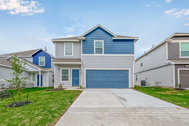 a front view of a house with a yard and a garage