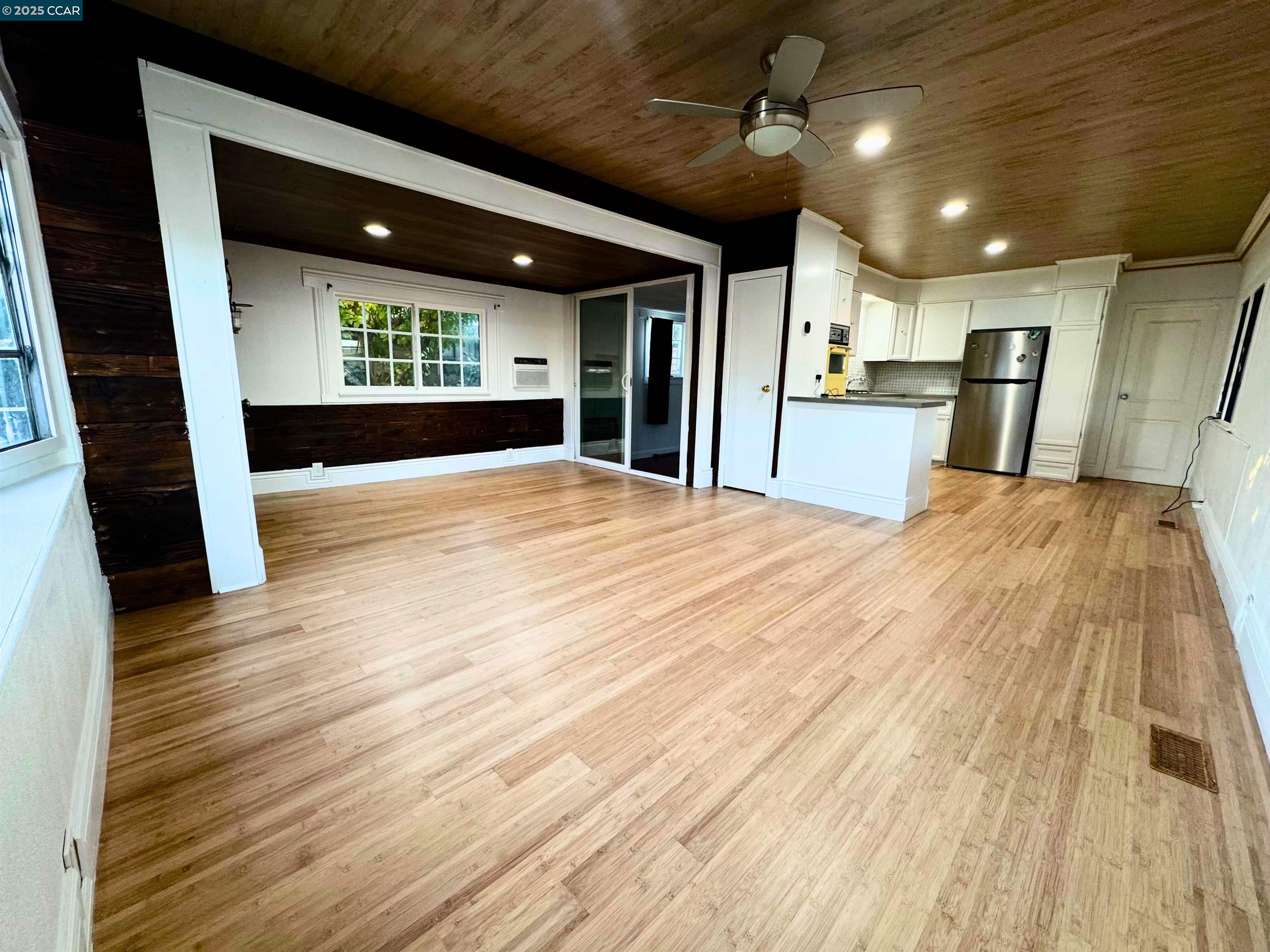 55 Pacifica Avenue, Unit 110 Bay Point, CA 94565 - Photo 5 of 20 a view of an empty room with wooden floor and a kitchen