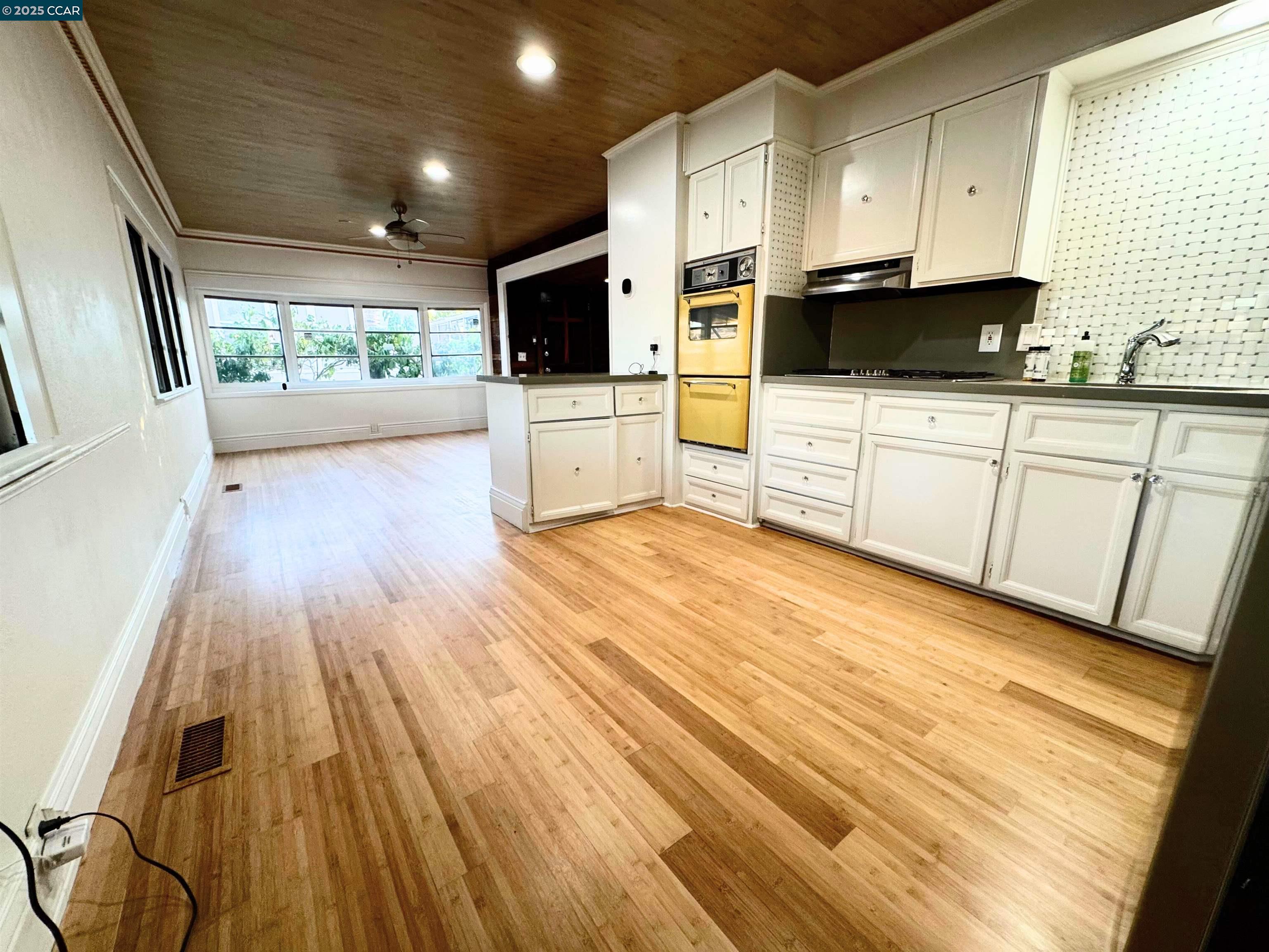 55 Pacifica Avenue, Unit 110 Bay Point, CA 94565 - Photo 9 of 20 a kitchen with wooden floors and white cabinets