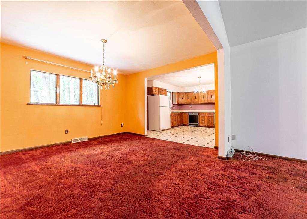 144 Cooper Road Cabot, PA 16023 - Photo 10 of 25 a view of an empty room with window wooden floor and a kitchen