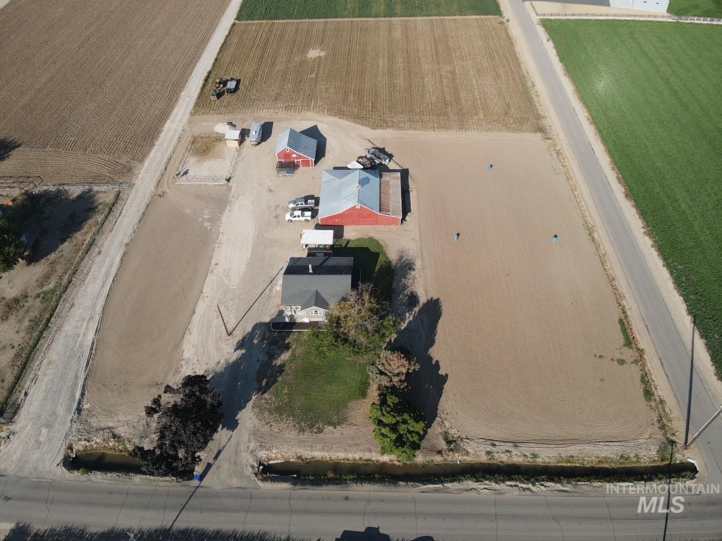 7425 Elmore Road Fruitland, ID 83619 - Photo 2 of 45 Expansive land parcel featuring a residential structure, multiple outbuildings, and surrounding agricultural fields