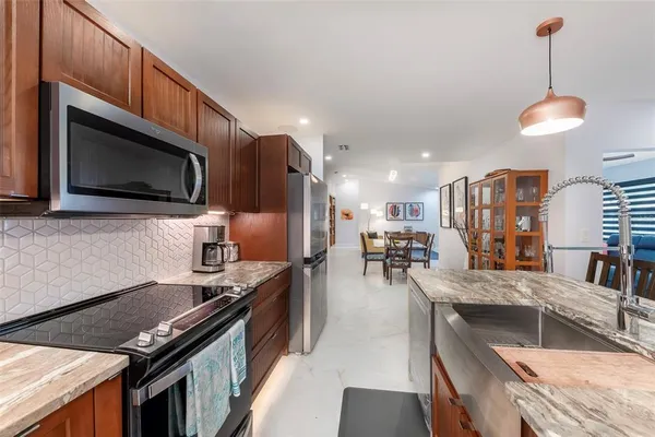 a kitchen with stainless steel appliances granite countertop a stove a sink dishwasher a microwave oven with granite countertops and cabinets