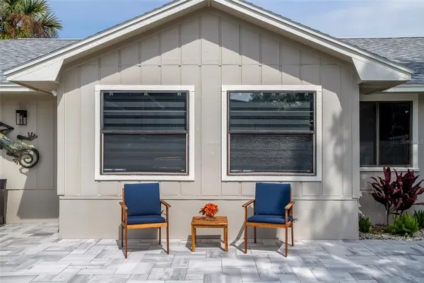 a patio with a table and chairs and potted plants