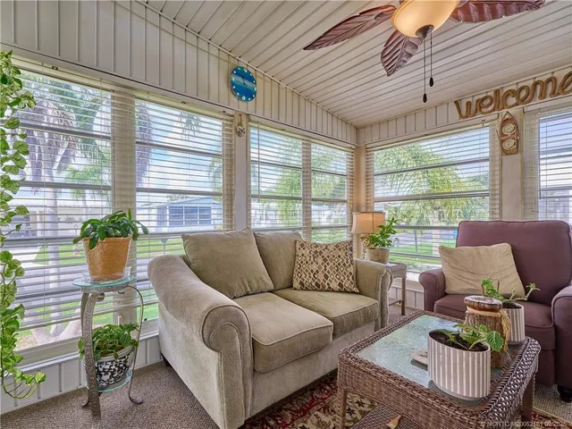 a living room with furniture and a floor to ceiling window