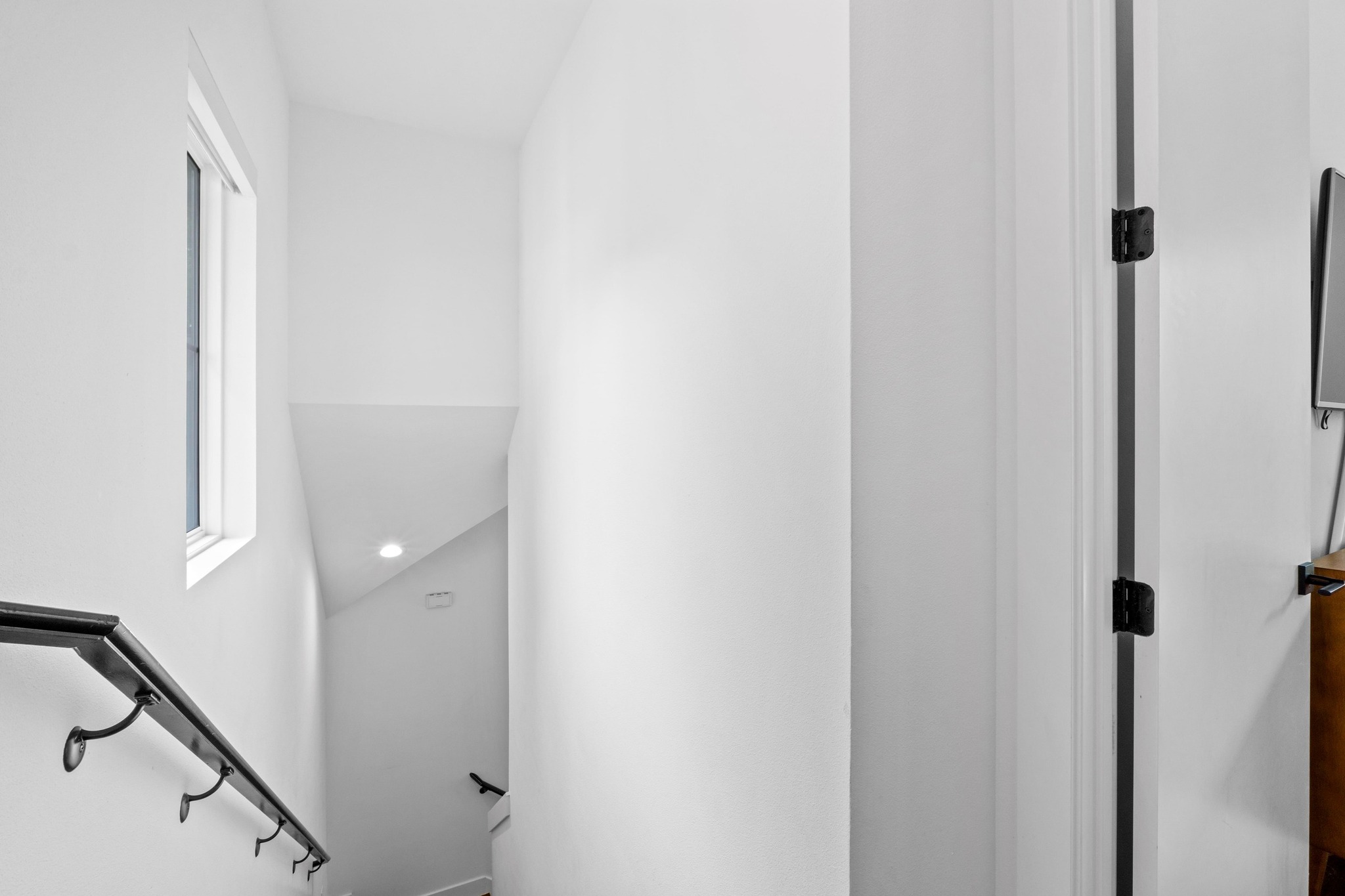 1706 Perez Street, Unit 2 Austin, TX 78721 - Photo 17 of 29 A well-lit stairwell features a dark handrail, guiding the ascent to the next level.