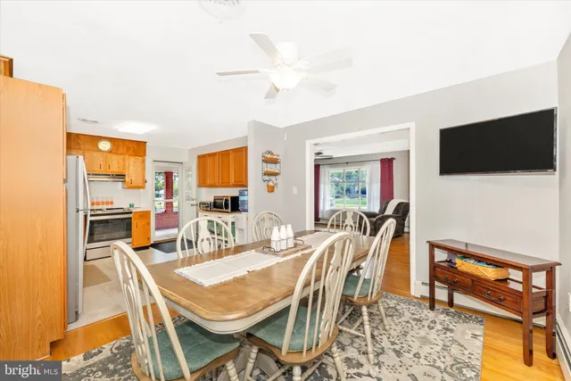 a kitchen with a refrigerator a stove a sink dishwasher a oven with white cabinets and wooden floor