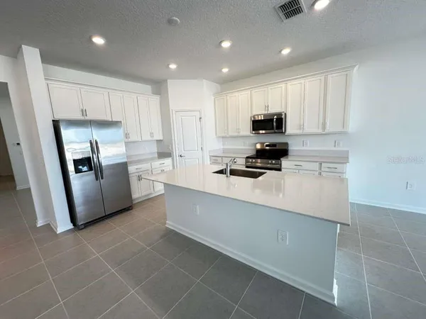 a kitchen with stainless steel appliances a refrigerator sink microwave and cabinets