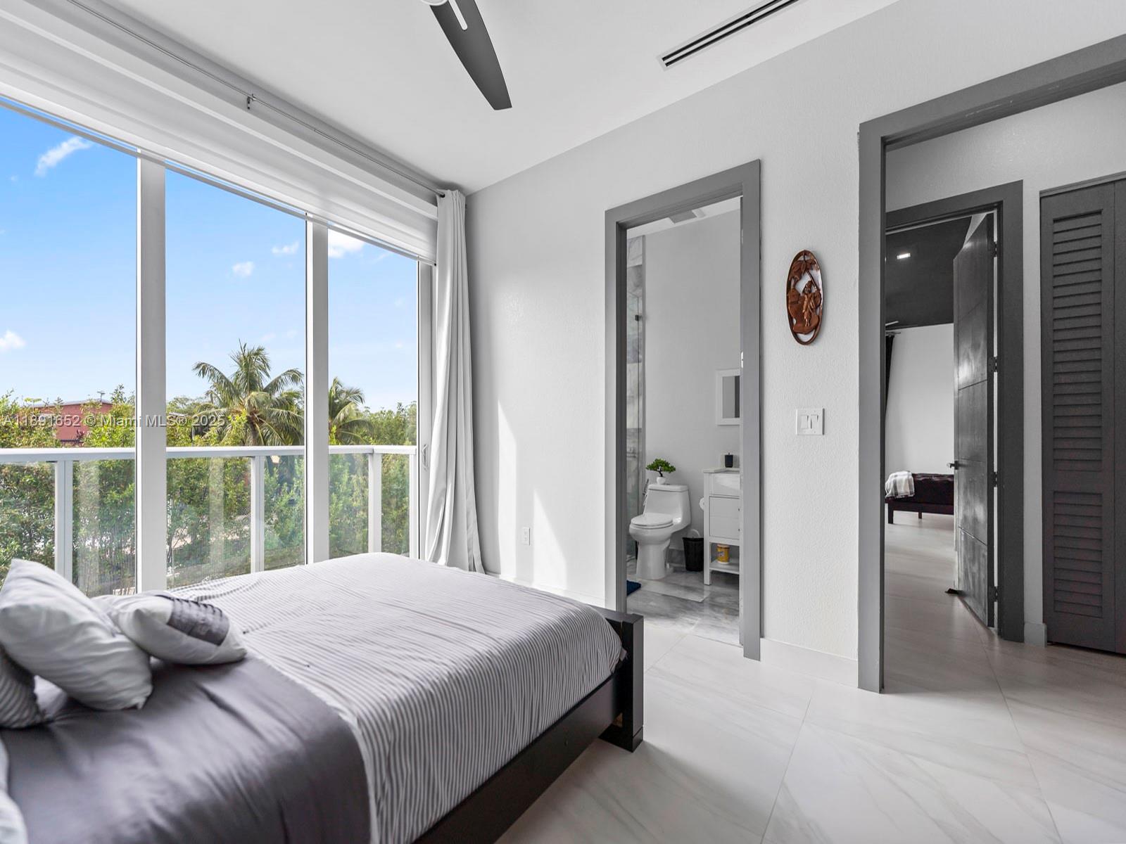 474 Bahia Honda Road Key Largo, FL 33037 - Photo 18 of 33 a bedroom with a bed and large windows