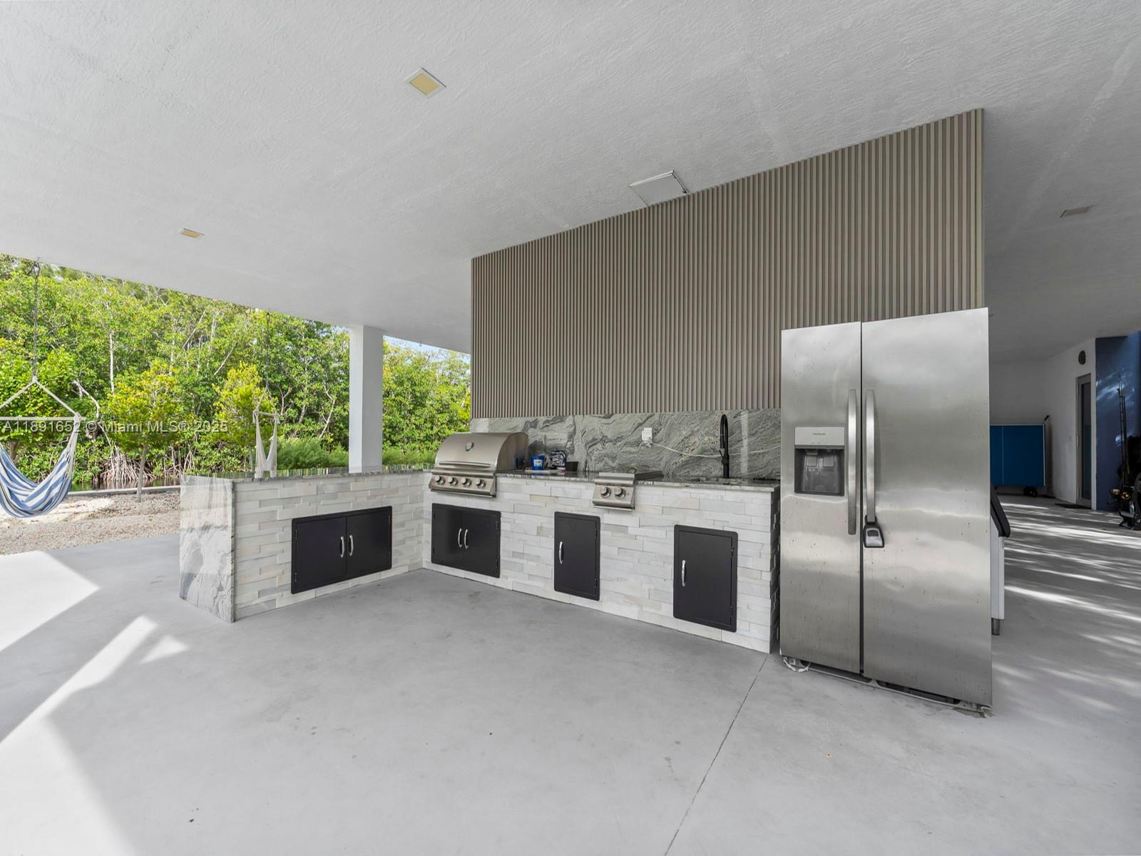 474 Bahia Honda Road Key Largo, FL 33037 - Photo 26 of 33 a kitchen with stainless steel appliances granite countertop a stove a sink and a refrigerator