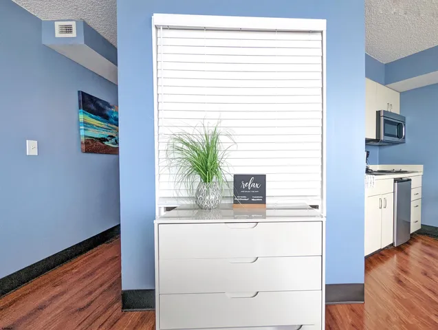 a hallway with a large window and wooden floor