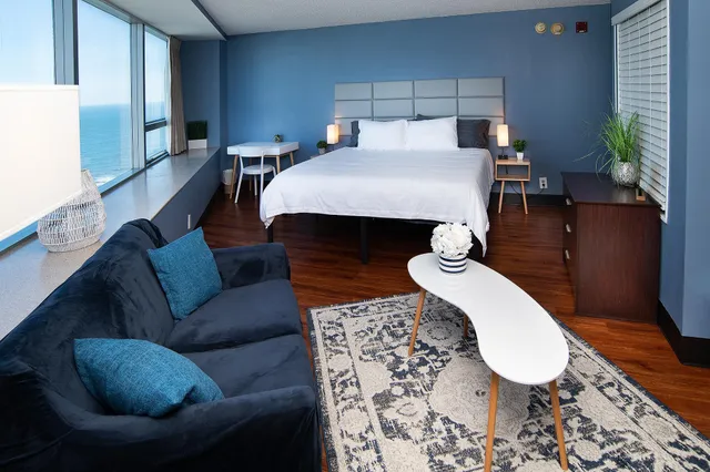 a bed room with a bed couch and a potted plant