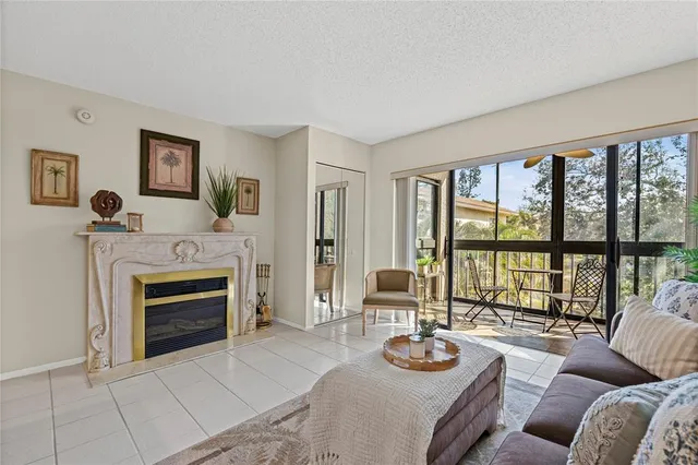 a living room with furniture a fireplace and a floor to ceiling window