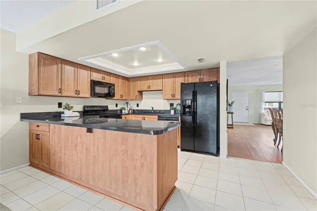 a kitchen with stainless steel appliances granite countertop a refrigerator and a stove top oven
