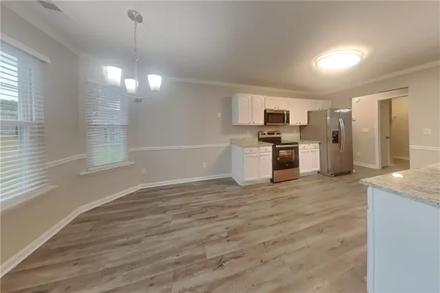 a view of a kitchen with a sink wooden cabinet and stainless steel appliances