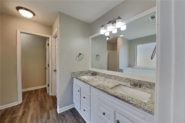 a bathroom with a granite countertop sink and a mirror