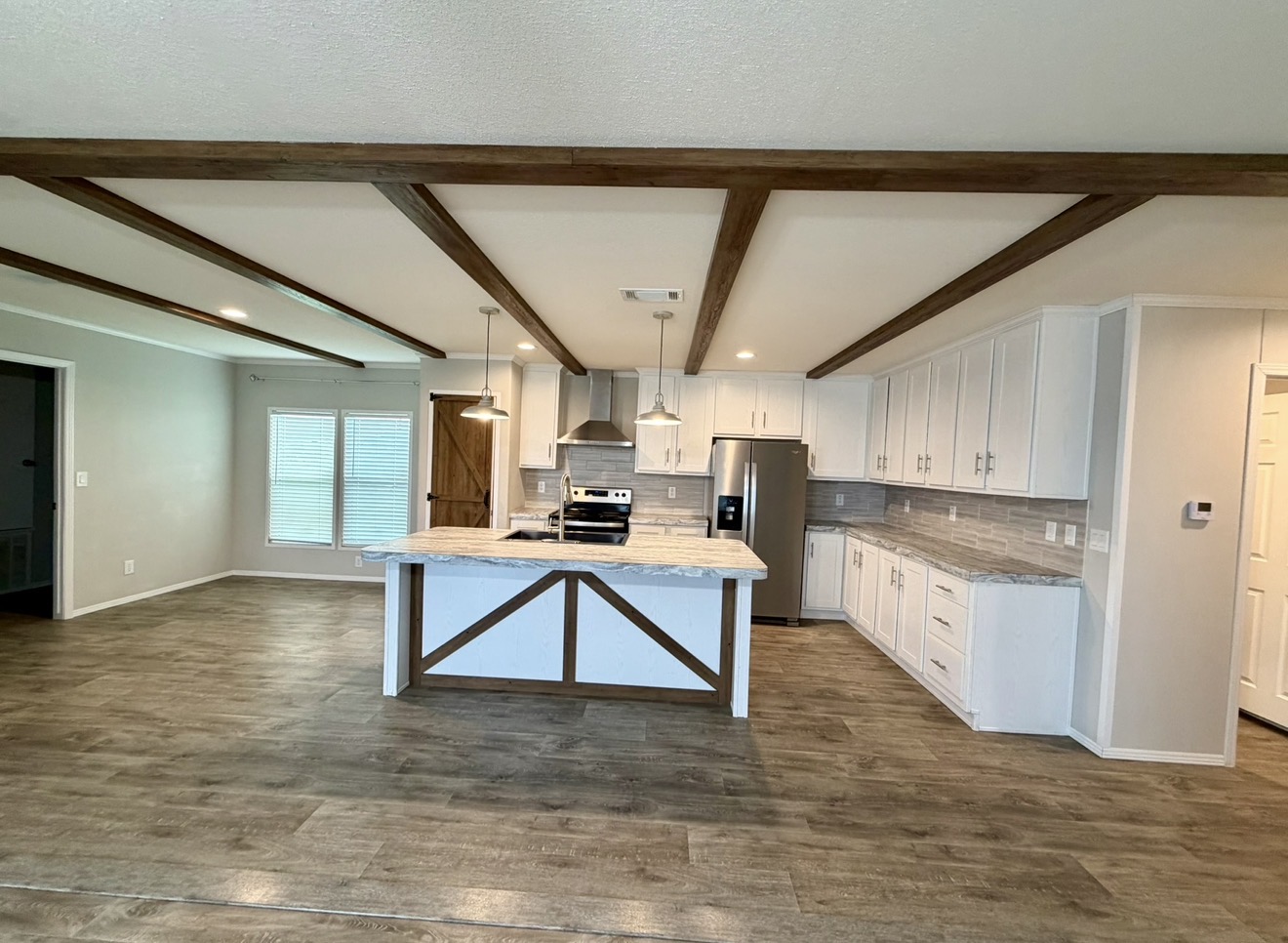 126 Castellana Way Elgin, TX 78621 - Photo 2 of 19 a kitchen with kitchen island a stove a sink and a refrigerator