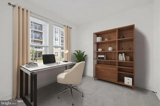 a view of a workspace with furniture and a window