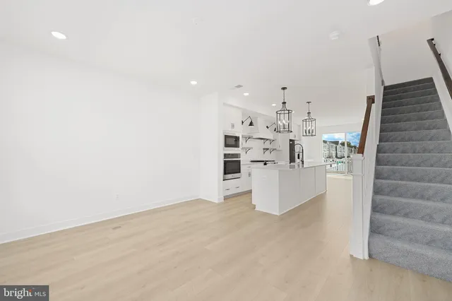 wooden floor in kitchen and an empty room
