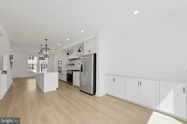 a view of a kitchen with refrigerator and white walls