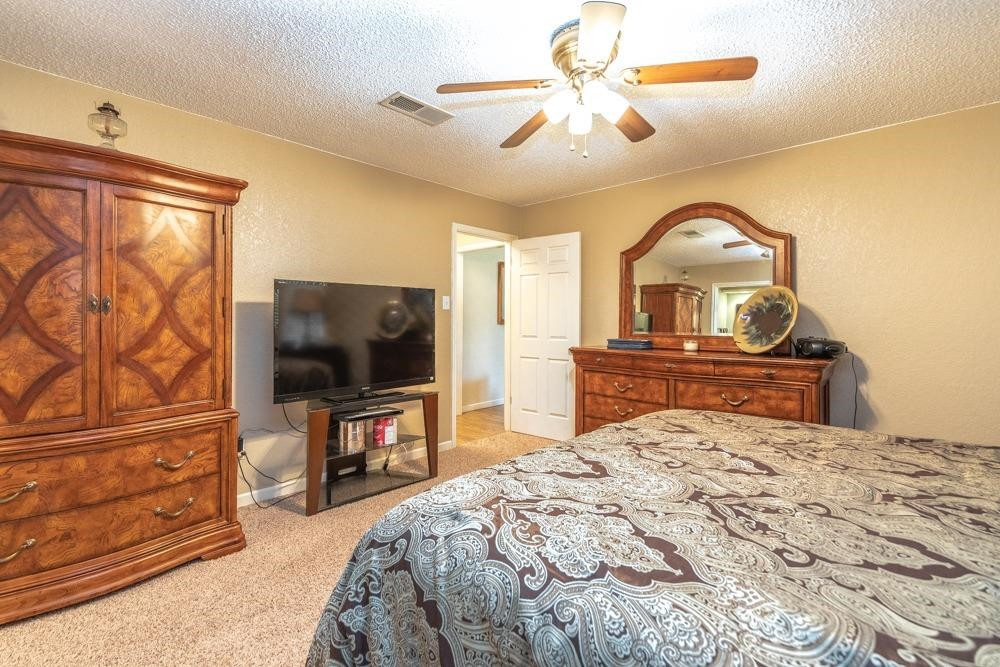 5402 94th Street Lubbock, TX 79424 - Photo 11 of 24 a bedroom with a bed and a flat screen tv