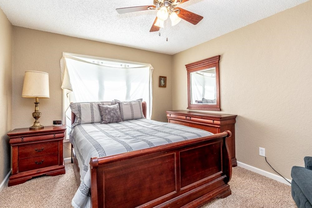 5402 94th Street Lubbock, TX 79424 - Photo 14 of 24 a bedroom with a bed and a dresser