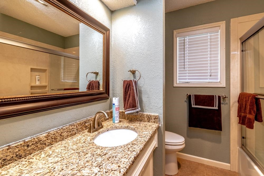 5402 94th Street Lubbock, TX 79424 - Photo 15 of 24 a bathroom with a granite countertop sink and a mirror