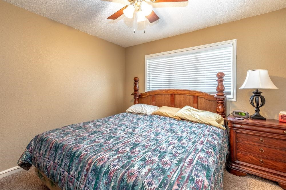 5402 94th Street Lubbock, TX 79424 - Photo 16 of 24 a bed sitting in a bedroom next to a lamp