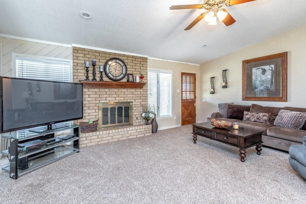 5402 94th Street Lubbock, TX 79424 - Photo 5 of 24 a living room with furniture a fireplace and a flat screen tv