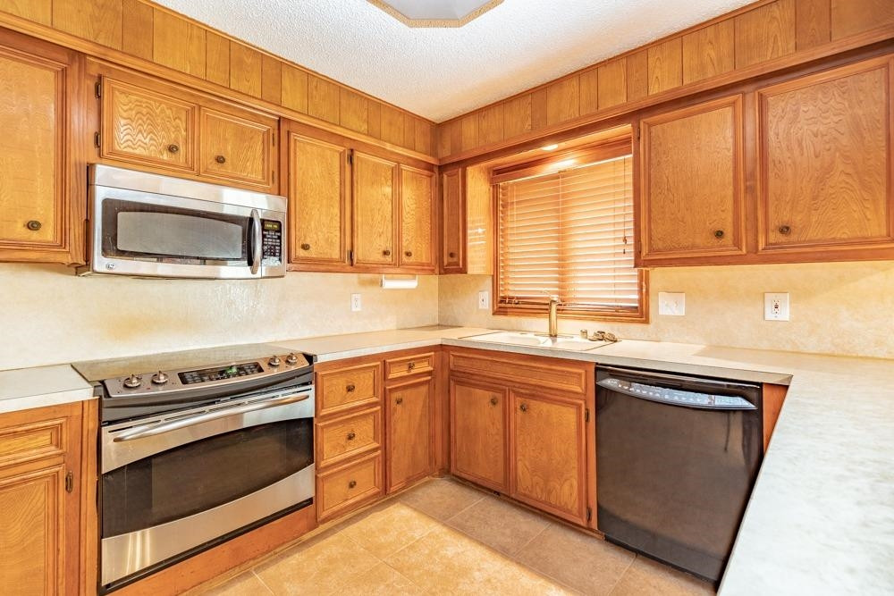 5402 94th Street Lubbock, TX 79424 - Photo 8 of 24 a kitchen with granite countertop cabinets stainless steel appliances and a sink