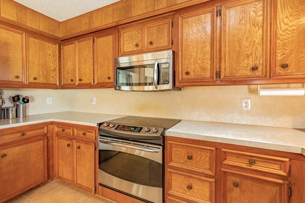 5402 94th Street Lubbock, TX 79424 - Photo 9 of 24 a kitchen with granite countertop cabinets stainless steel appliances and a counter space