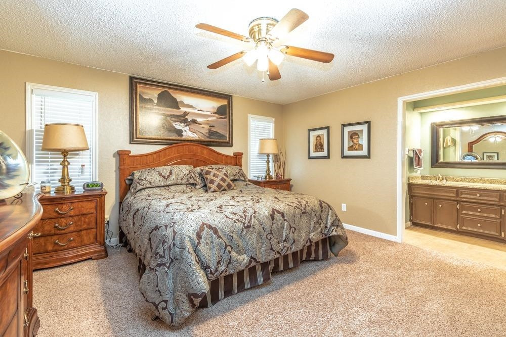 5402 94th Street Lubbock, TX 79424 - Photo 10 of 24 a bedroom with a bed and a chandelier