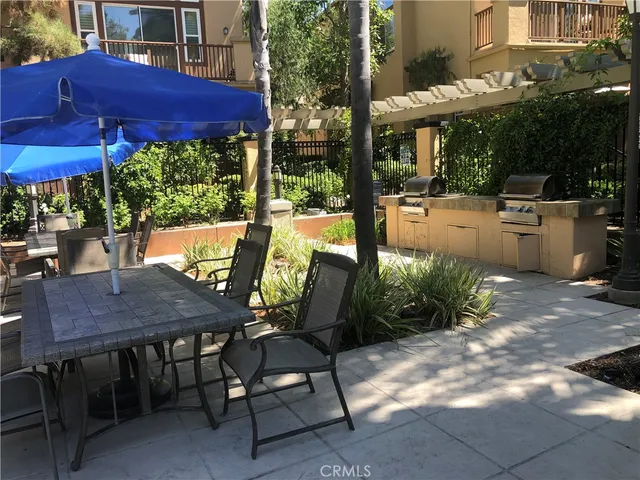 a view of a patio with table and chairs under an umbrella