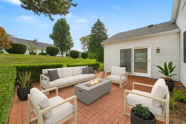 a view of a patio with couches table and chairs with wooden fence