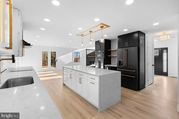 a kitchen with kitchen island a counter and a refrigerator