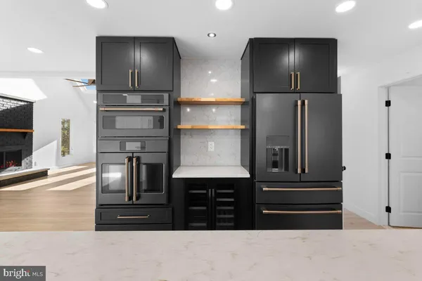 a kitchen with stainless steel appliances granite countertop a sink a stove a refrigerator and a oven